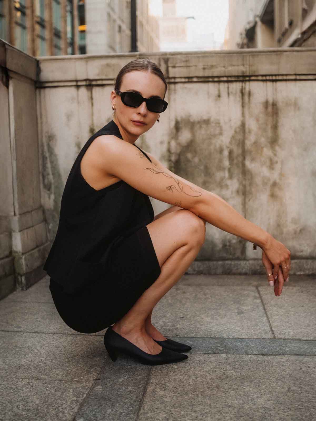 kobieta czarnej sukience w czarnych czółenkach na niskim obcasie